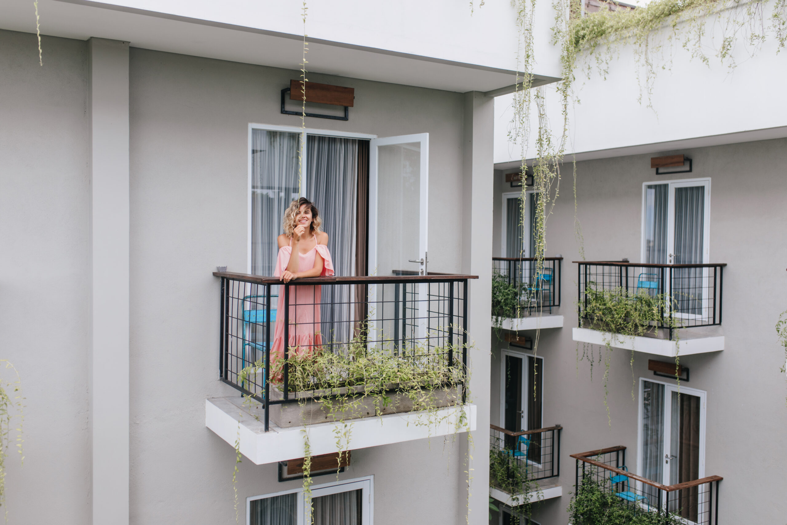 kobieta stojąca na balkonie w tle okna balkonowe
